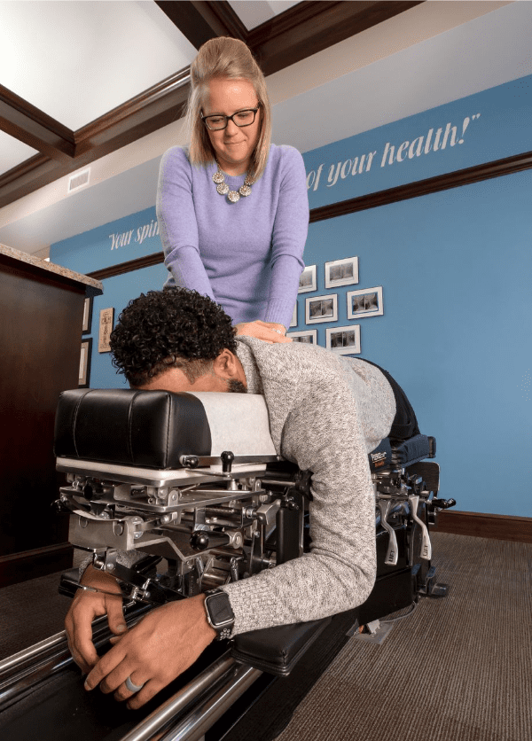 Dr. Marie gives a male a chiropractic adjustment at her Dublin, OH chiropractor office.